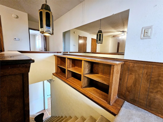 interior space with ceiling fan, light carpet, and a textured ceiling