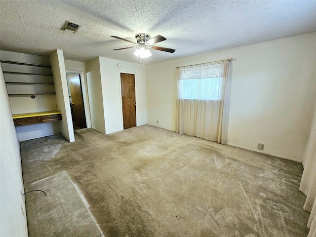 unfurnished bedroom with carpet floors, a textured ceiling, and ceiling fan