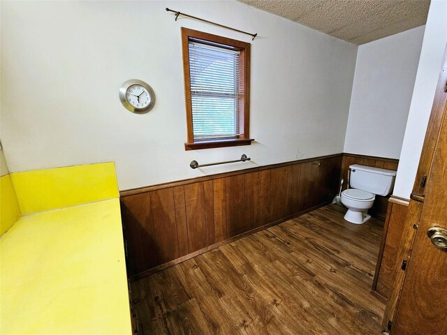 bathroom featuring wood walls, vanity, wood-type flooring, and a textured ceiling