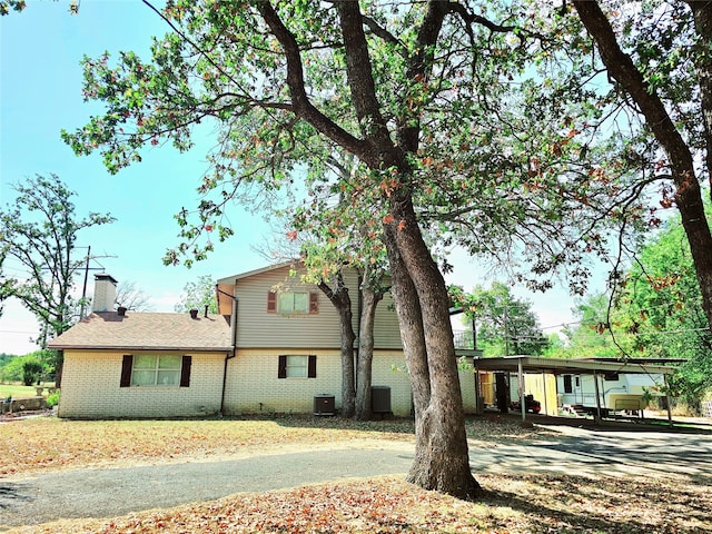 back of house featuring a carport and central AC