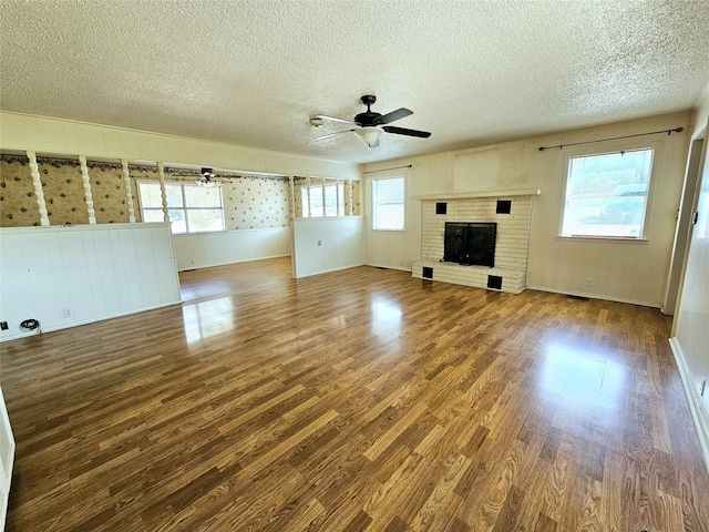 unfurnished living room featuring hardwood / wood-style flooring, ceiling fan, and plenty of natural light