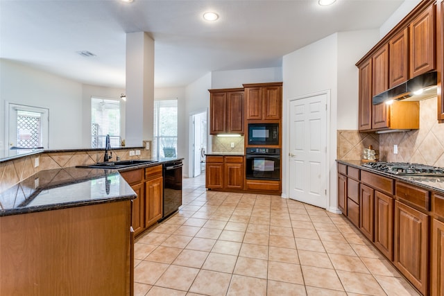 kitchen featuring dark stone countertops, sink, decorative backsplash, black appliances, and light tile patterned floors