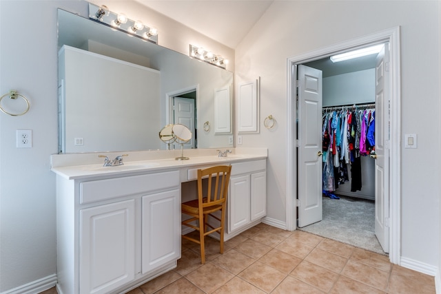 bathroom with tile patterned floors, vaulted ceiling, and vanity