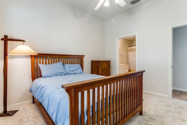 bedroom featuring ceiling fan, connected bathroom, and light colored carpet