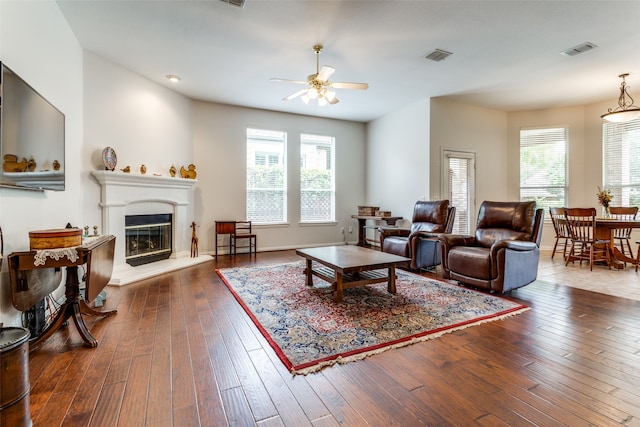 living room featuring ceiling fan, plenty of natural light, and dark hardwood / wood-style flooring