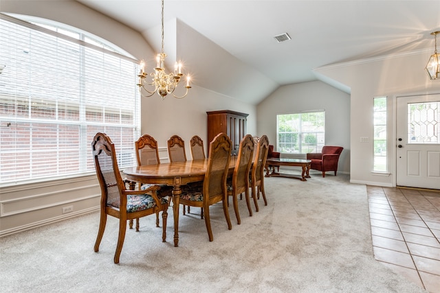 dining room with an inviting chandelier, lofted ceiling, light tile patterned floors, and a healthy amount of sunlight