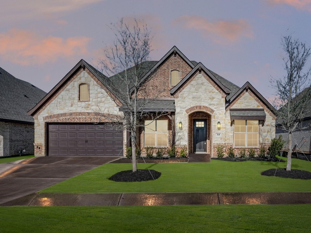 french country home with a garage and a yard