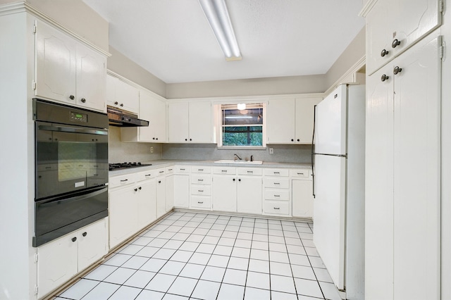 kitchen with gas stovetop, white refrigerator, white cabinetry, and oven