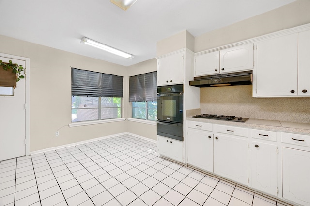 kitchen with light tile patterned flooring, tasteful backsplash, oven, stainless steel gas stovetop, and white cabinets