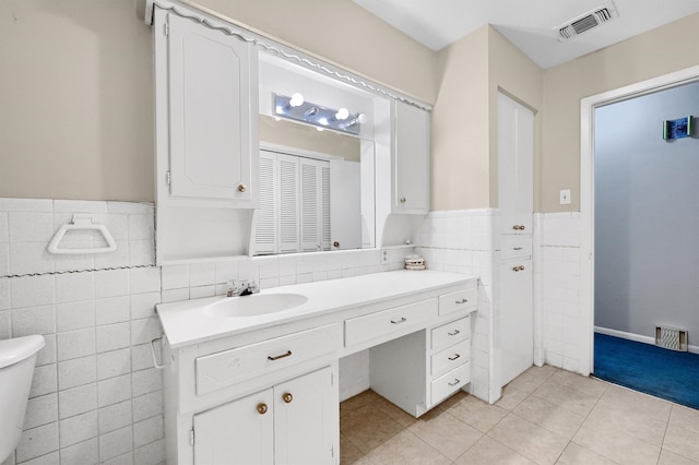 bathroom featuring vanity, tile walls, toilet, and tile patterned floors