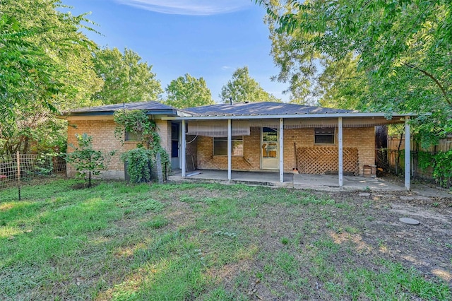 back of property with a patio and a lawn