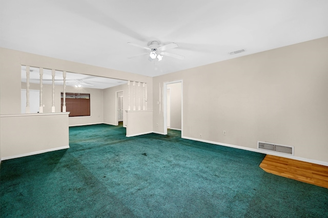 unfurnished living room with ceiling fan and dark colored carpet