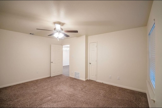 unfurnished bedroom with dark colored carpet and ceiling fan