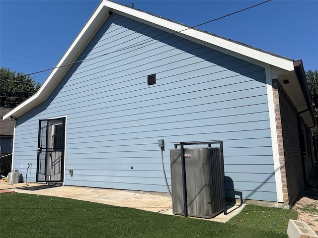 view of home's exterior with a lawn and central AC