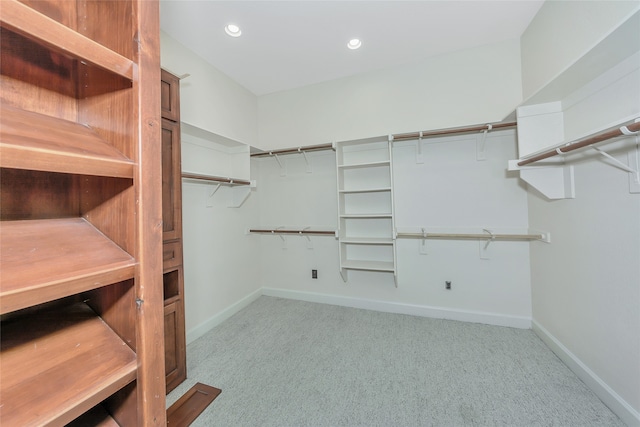 walk in closet featuring light carpet