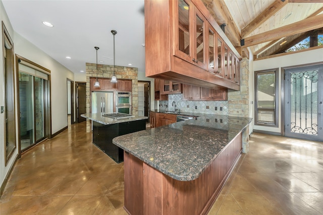 kitchen featuring lofted ceiling with beams, dark stone counters, decorative light fixtures, and a center island