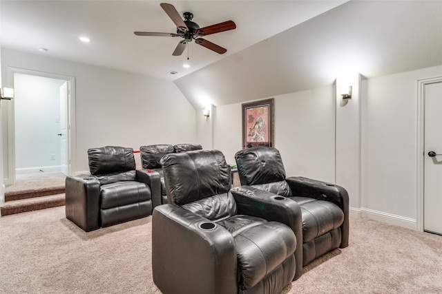 home theater room featuring ceiling fan, light colored carpet, and vaulted ceiling