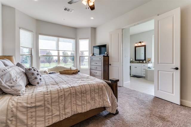 carpeted bedroom with ceiling fan and ensuite bath