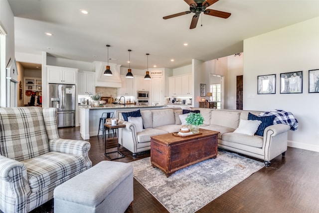 living room featuring dark hardwood / wood-style floors, sink, and ceiling fan