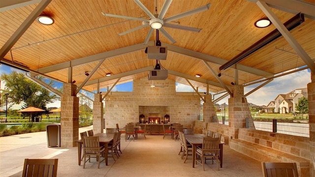 view of patio / terrace featuring a gazebo, an outdoor brick fireplace, and ceiling fan