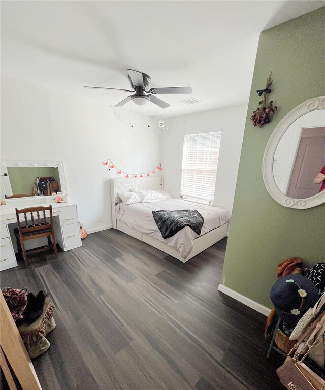 bedroom with ceiling fan, dark hardwood / wood-style floors, and built in desk