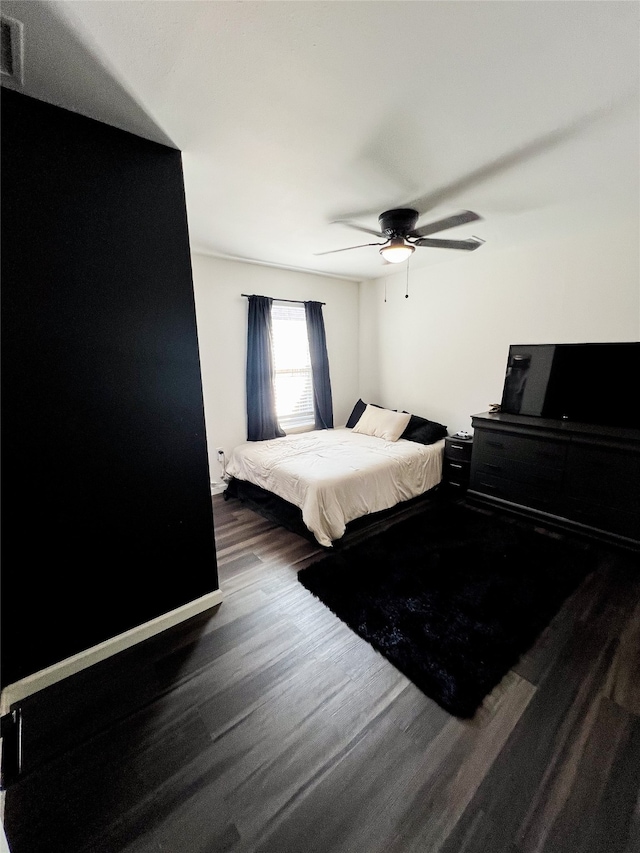 bedroom with ceiling fan and dark wood-type flooring