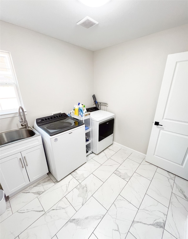 washroom with separate washer and dryer, cabinets, and sink