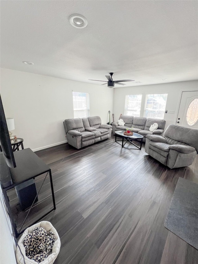 living room with ceiling fan and dark hardwood / wood-style flooring