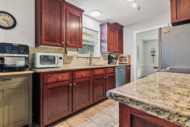 kitchen featuring backsplash, appliances with stainless steel finishes, a barn door, and sink