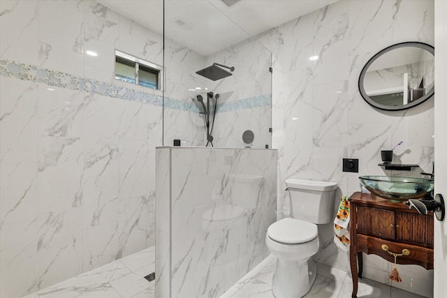 bathroom with a shower, tile walls, vanity, and toilet