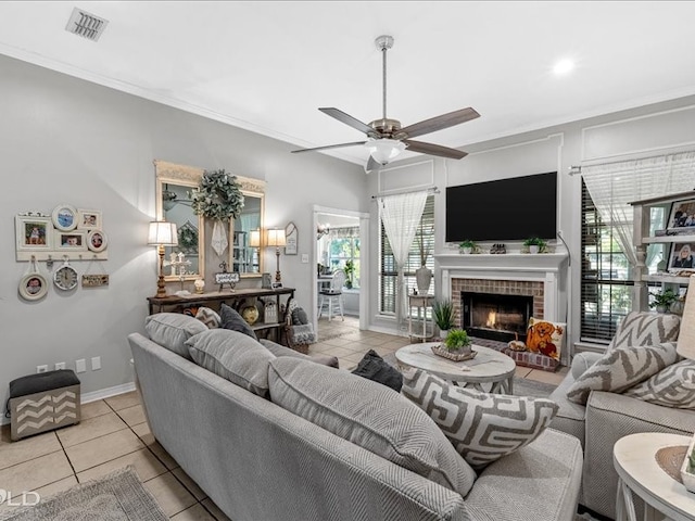 tiled living room with a fireplace, crown molding, and ceiling fan