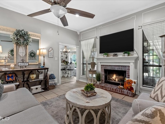 tiled living room featuring a brick fireplace, ceiling fan with notable chandelier, and crown molding