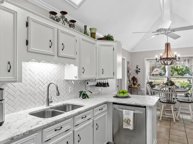 kitchen featuring lofted ceiling, decorative backsplash, stainless steel dishwasher, sink, and white cabinetry