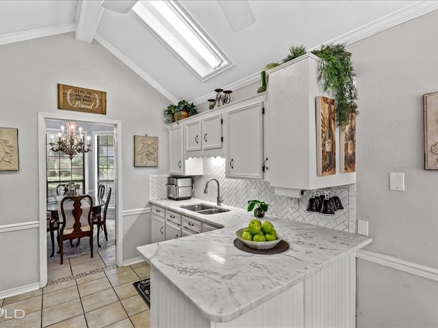 kitchen featuring white cabinets, sink, kitchen peninsula, tasteful backsplash, and lofted ceiling with beams