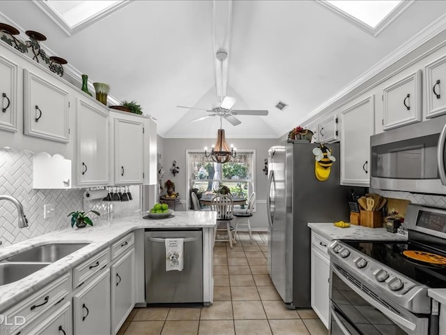 kitchen with lofted ceiling with beams, stainless steel appliances, white cabinets, sink, and light tile patterned floors