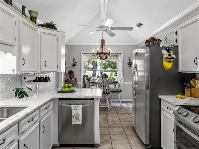 kitchen with light tile patterned floors, white cabinets, stainless steel appliances, and vaulted ceiling