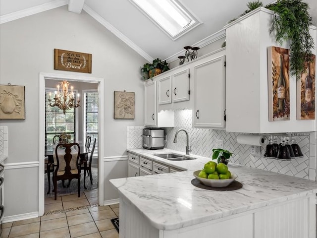 kitchen featuring tasteful backsplash, sink, kitchen peninsula, vaulted ceiling with beams, and white cabinetry