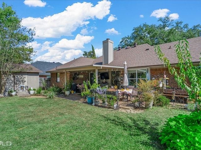 back of house featuring a patio area and a lawn