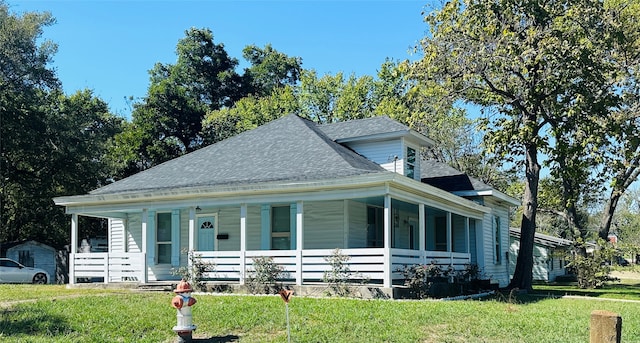 view of front facade with a front yard and covered porch