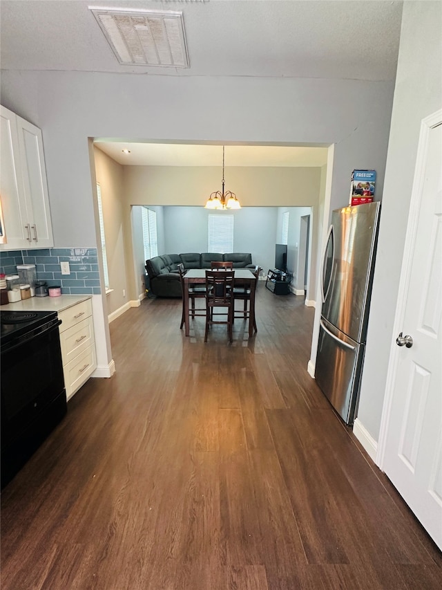 kitchen with stainless steel refrigerator, black range with electric cooktop, dark hardwood / wood-style flooring, and white cabinetry