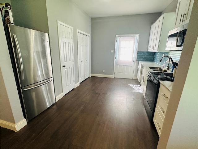 kitchen featuring stainless steel refrigerator, sink, dark hardwood / wood-style floors, white cabinets, and black electric range