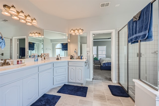 bathroom featuring tile patterned flooring, a shower with shower door, and vanity