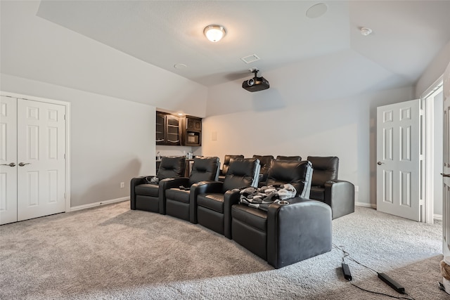 cinema room featuring carpet floors and vaulted ceiling