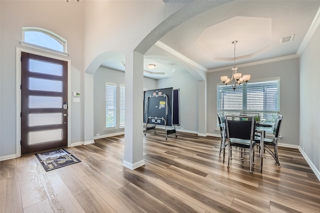 dining space with crown molding, a chandelier, hardwood / wood-style flooring, and a wealth of natural light