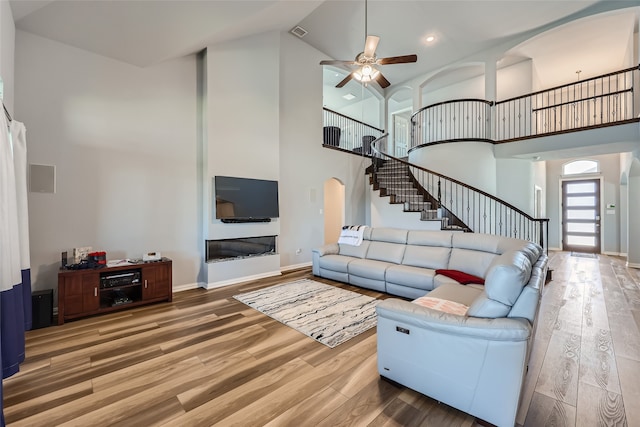 living room featuring high vaulted ceiling, ceiling fan, and hardwood / wood-style floors