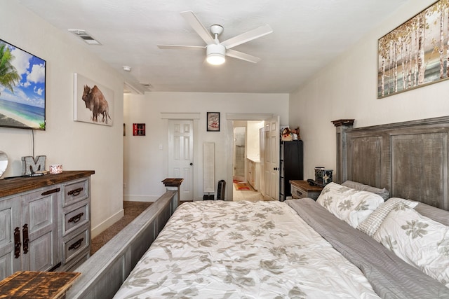 carpeted bedroom with ensuite bath and ceiling fan