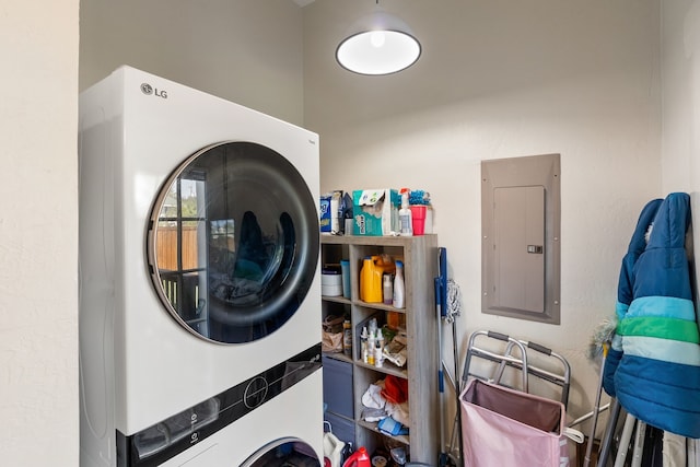 laundry area with electric panel and stacked washer / dryer