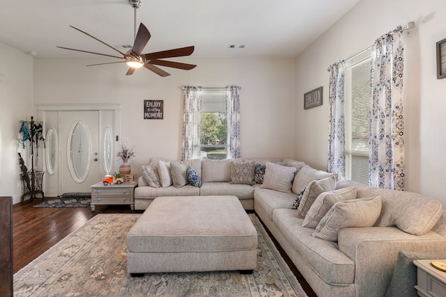 living room featuring ceiling fan and dark wood-type flooring