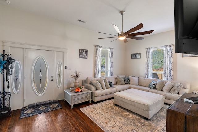 living room featuring ceiling fan and dark wood-type flooring