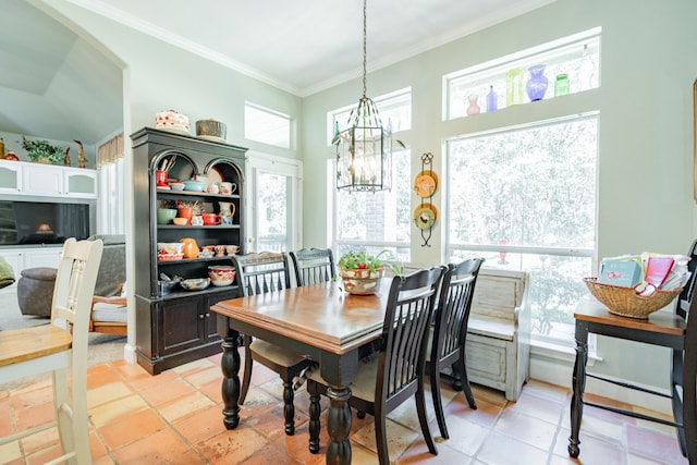 dining space with an inviting chandelier, crown molding, and light tile patterned flooring